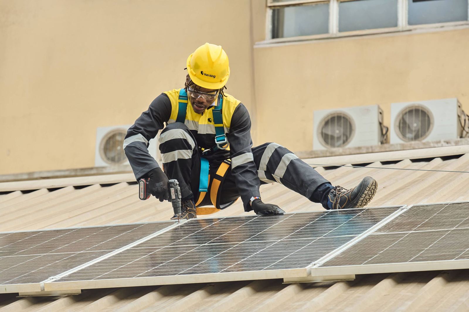 Technician installing rooftop solar panels on a Kenyan home